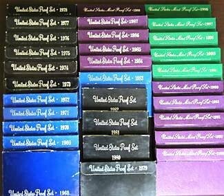 Stack of US proof coin set boxes from various years.